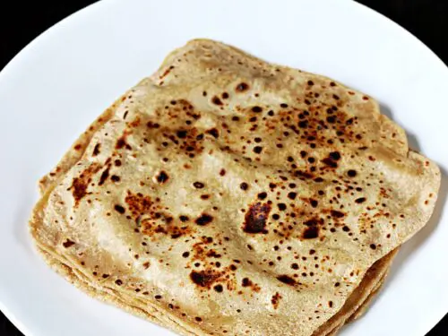 paratha served with chutney and vegetables