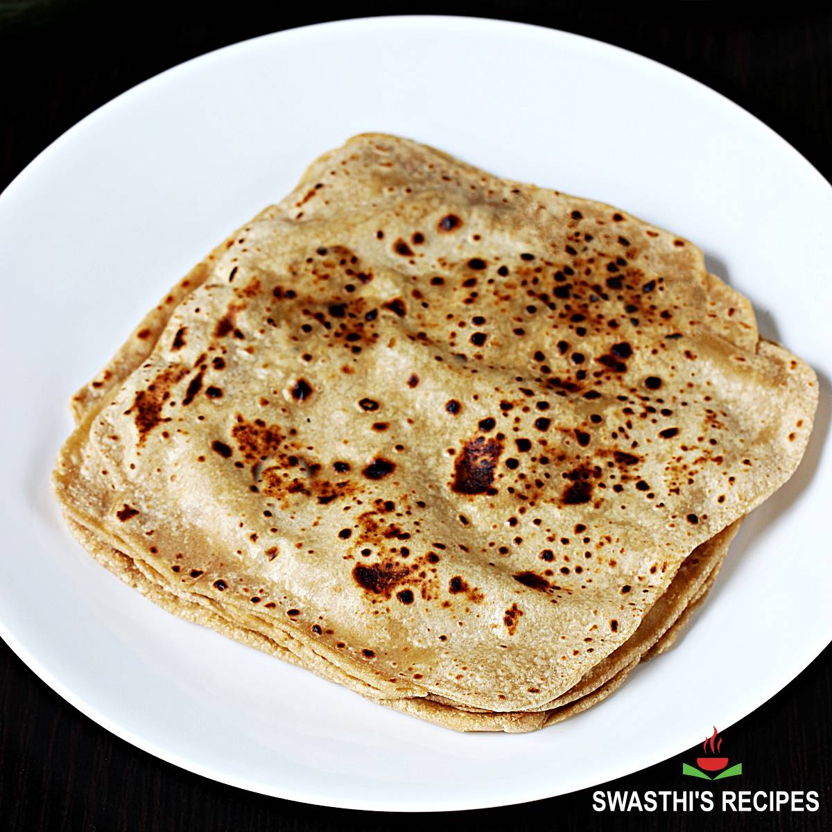 Making roti (Indian Chapati) on roti tawa made of wheat with hand