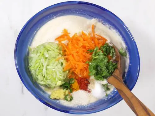 adding vegetables to handvo batter