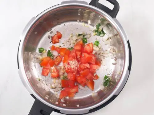 cooking tomatoes with salt to make moong dal tadka