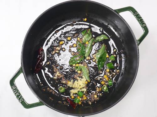 curry leaves and ginger being added to tempering