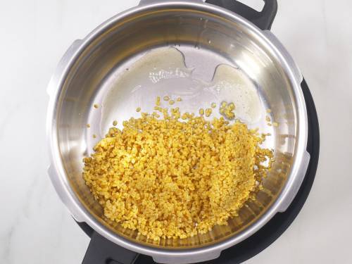 roasting moong dal to make ven pongal