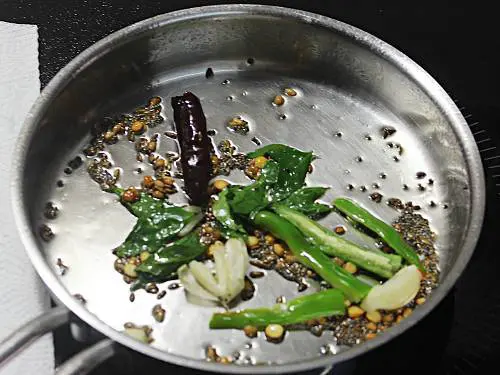 frying garlic and chilli to make horse gram dal