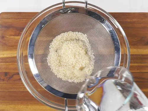 Rinse rice in colander to make phirni