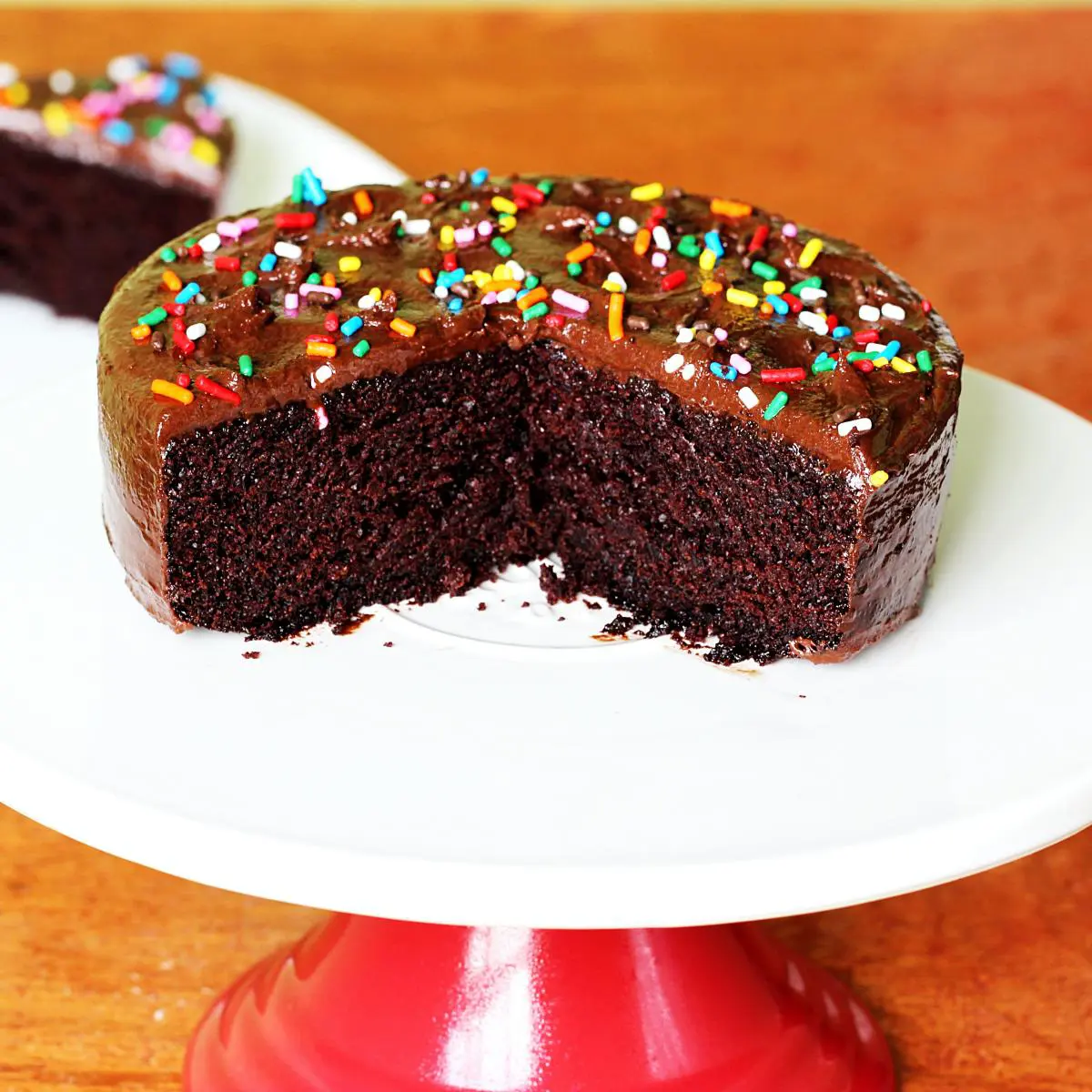 Eggless chocolate cake on a white cake stand