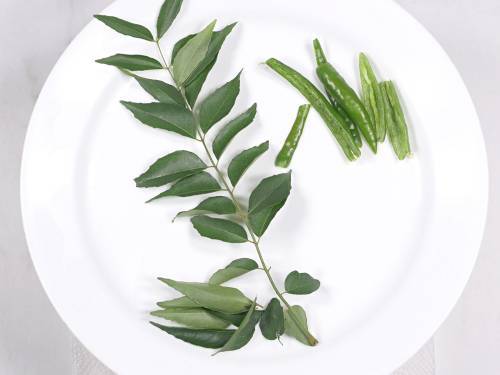rinse and pat dry curry leaves and deseed green chilies
