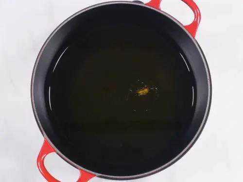 heating oil in a kadai to fry chicken 65