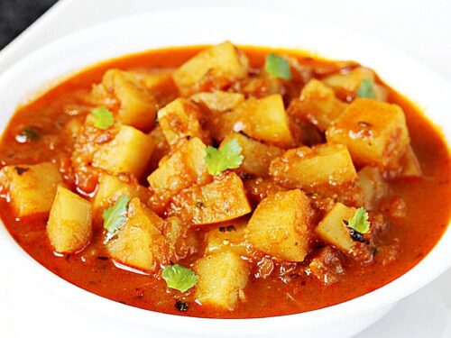 Potato curry also known as aloo curry in a white bowl