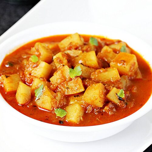 Potato curry also known as aloo curry in a white bowl