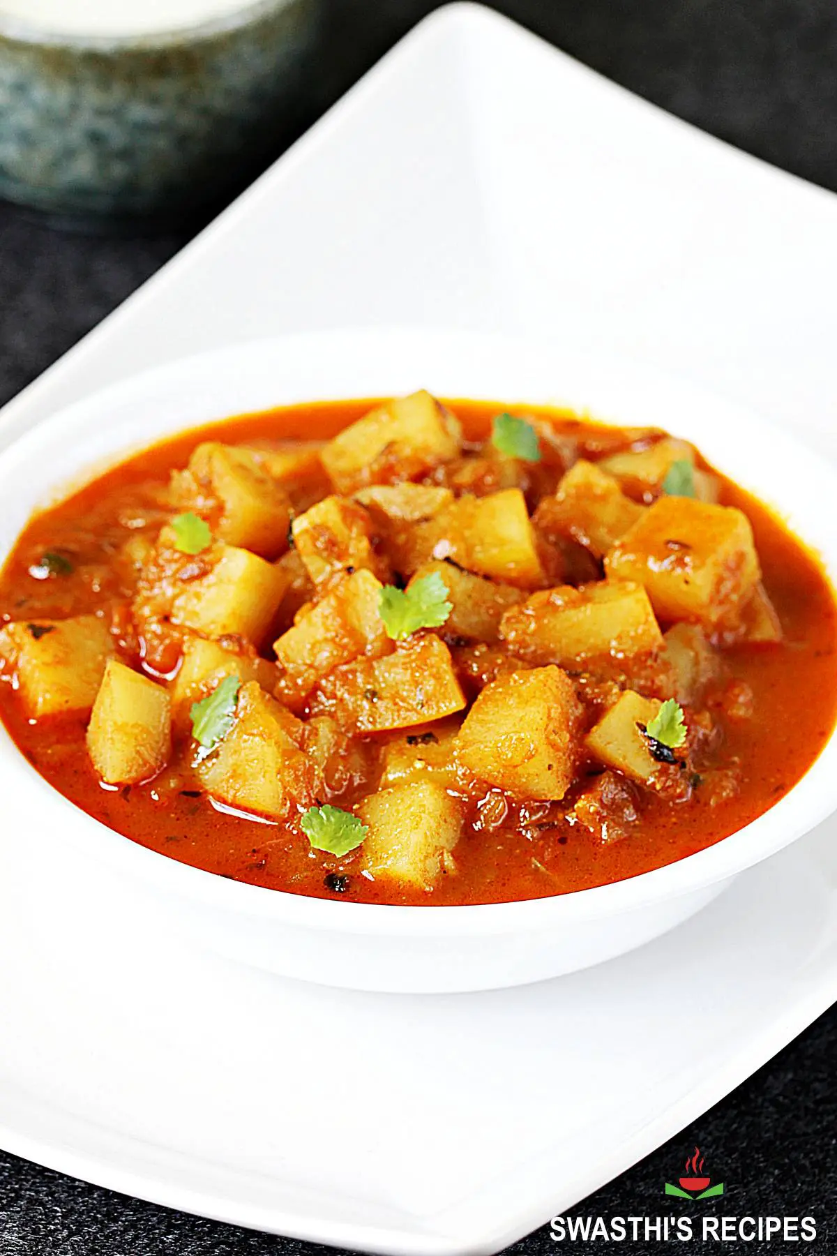 Potato curry also known as aloo curry in a white bowl