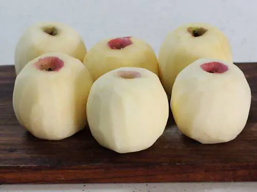 peeled apples on a chopping board for juicing