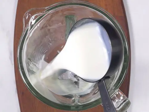 pour milk to blender