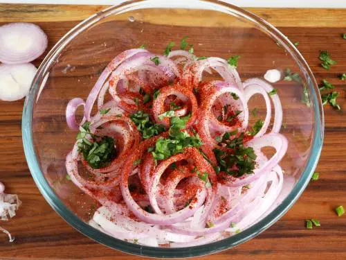 spices and herbs on onions in a bowl