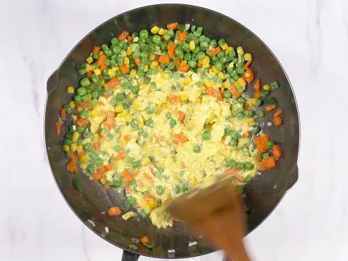 cooking eggs in a wok for quinoa fried rice