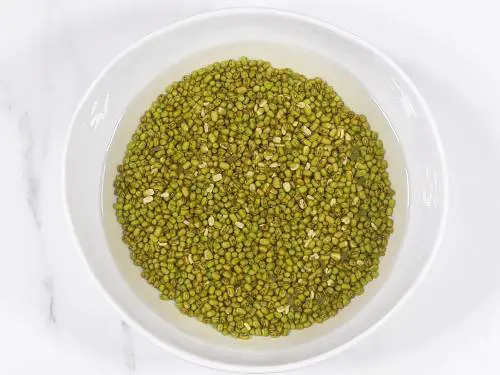 Green moong dal soaking in a bowl