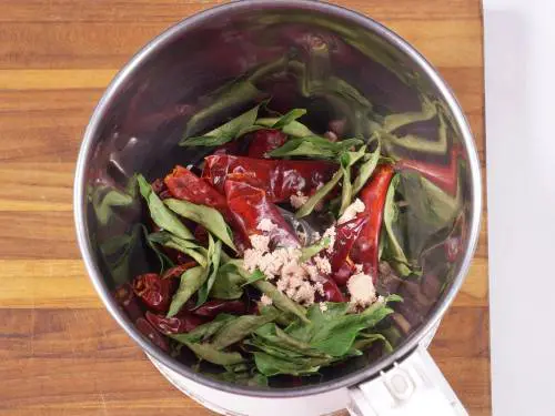 curry leaves and red chilies in a grinder