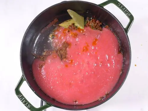 tomato puree being cooked in the pan