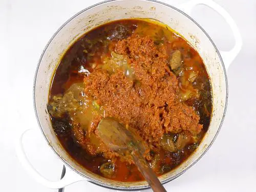 adding onion tomato masala to lamb