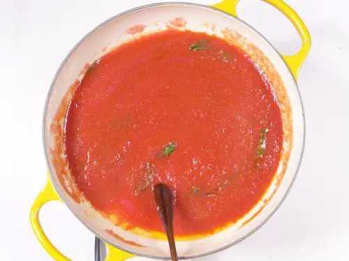 adding tomatoes to the pan