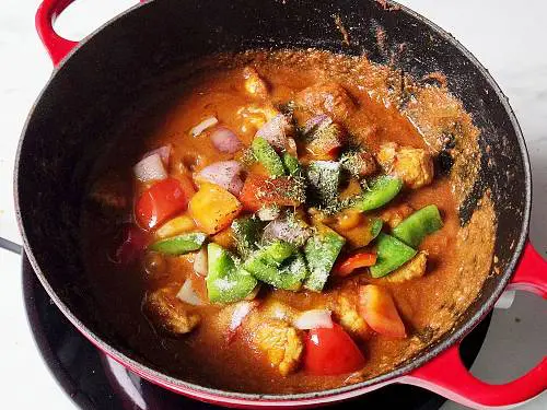 kadai chicken being simmered with bell peppers and kasuri methi