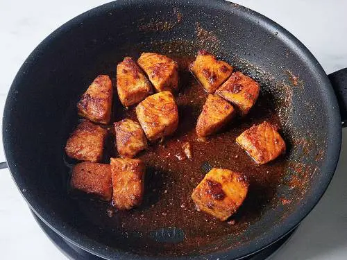 pan-fried salmon resting in a non-stick
