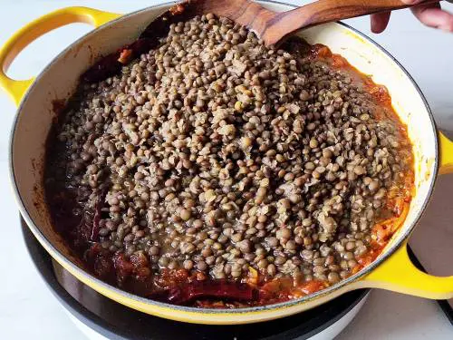 adding brown lentils to a pan