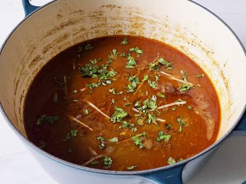 garnishing nihari with ginger coriander and chili