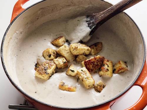 adding paneer to white curry