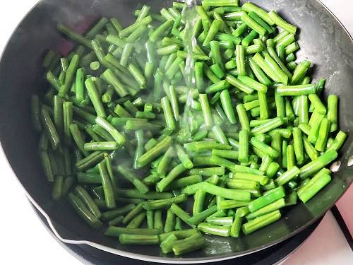 adding a splash of liquid on the green beans