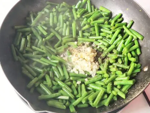 adding butter garlic and pepper on the green beans