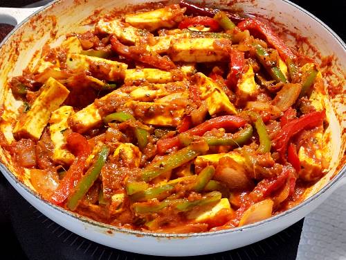 saucy paneer jalfrezi getting heated through in a pan