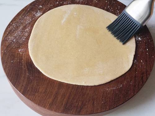 smearing ghee over the dough