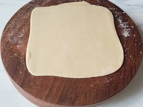 rolled square paratha on a rolling board