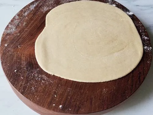 rolled dough on a wooden rolling board