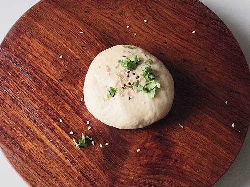 sprinkle seeds and coriander on dough ball
