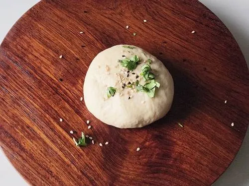 sprinkle seeds and coriander on dough ball