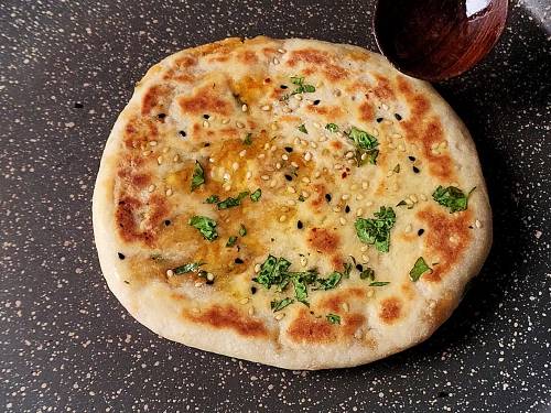 smearing butter on kulcha