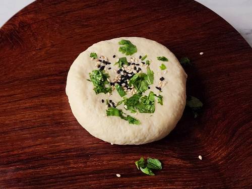 pressing some seeds on dough ball