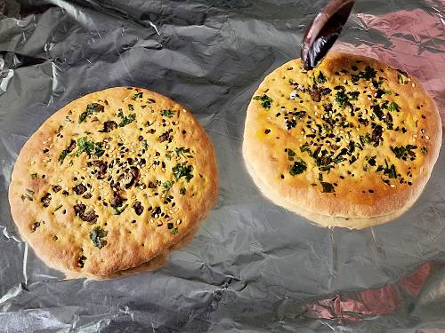 brushing melted butter on keema naan