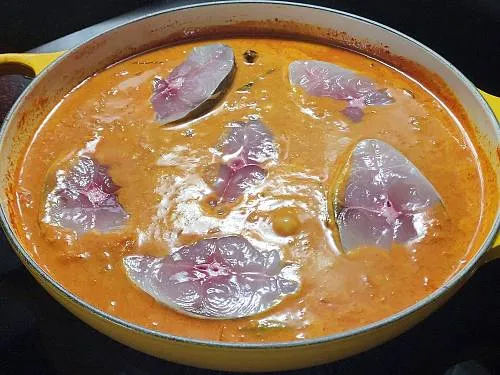 adding fish to the coconut curry