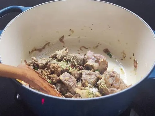 adding ground spices to make yakhni pulao