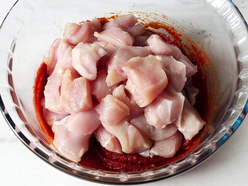 adding chicken to marinade